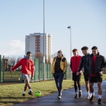Teenage boys walking and playing with a football