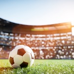 An illustrated image of a football on the pitch of a football stadium. 